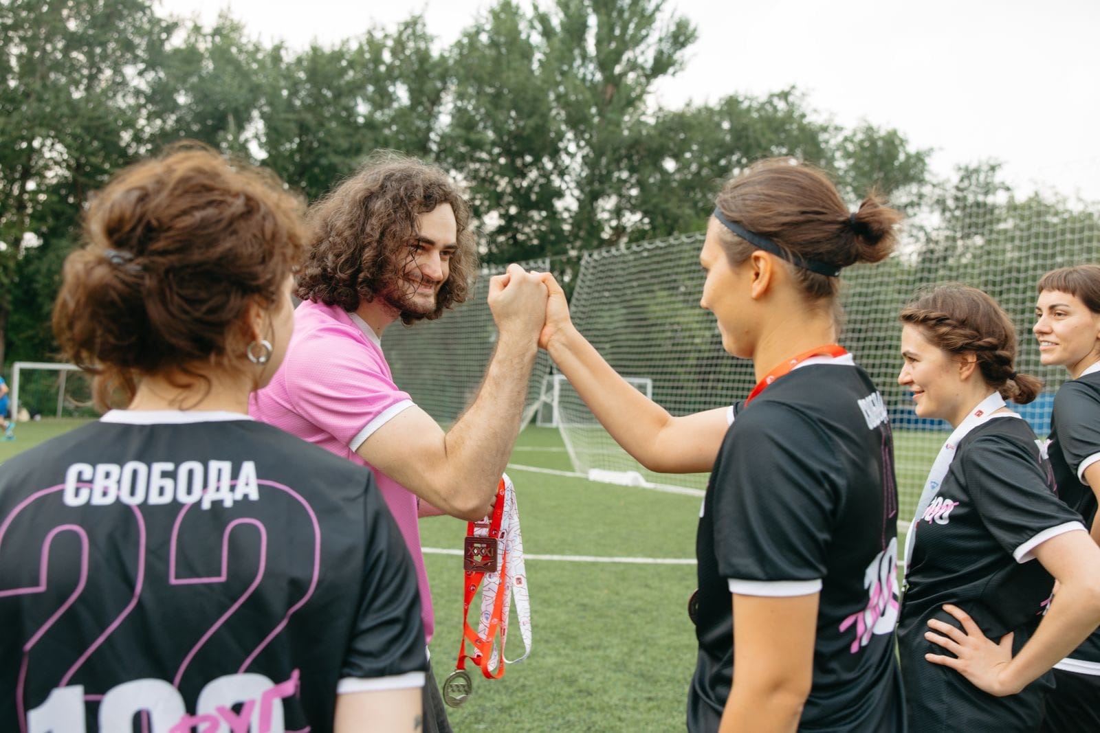 Players exchanging fist bumps after a recreational soccer match